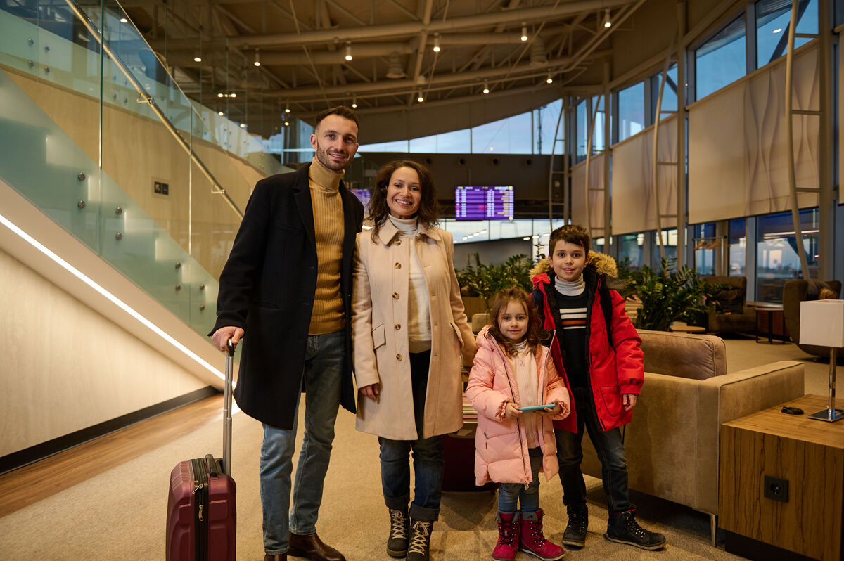 A family with luggage in an airport departure terminal