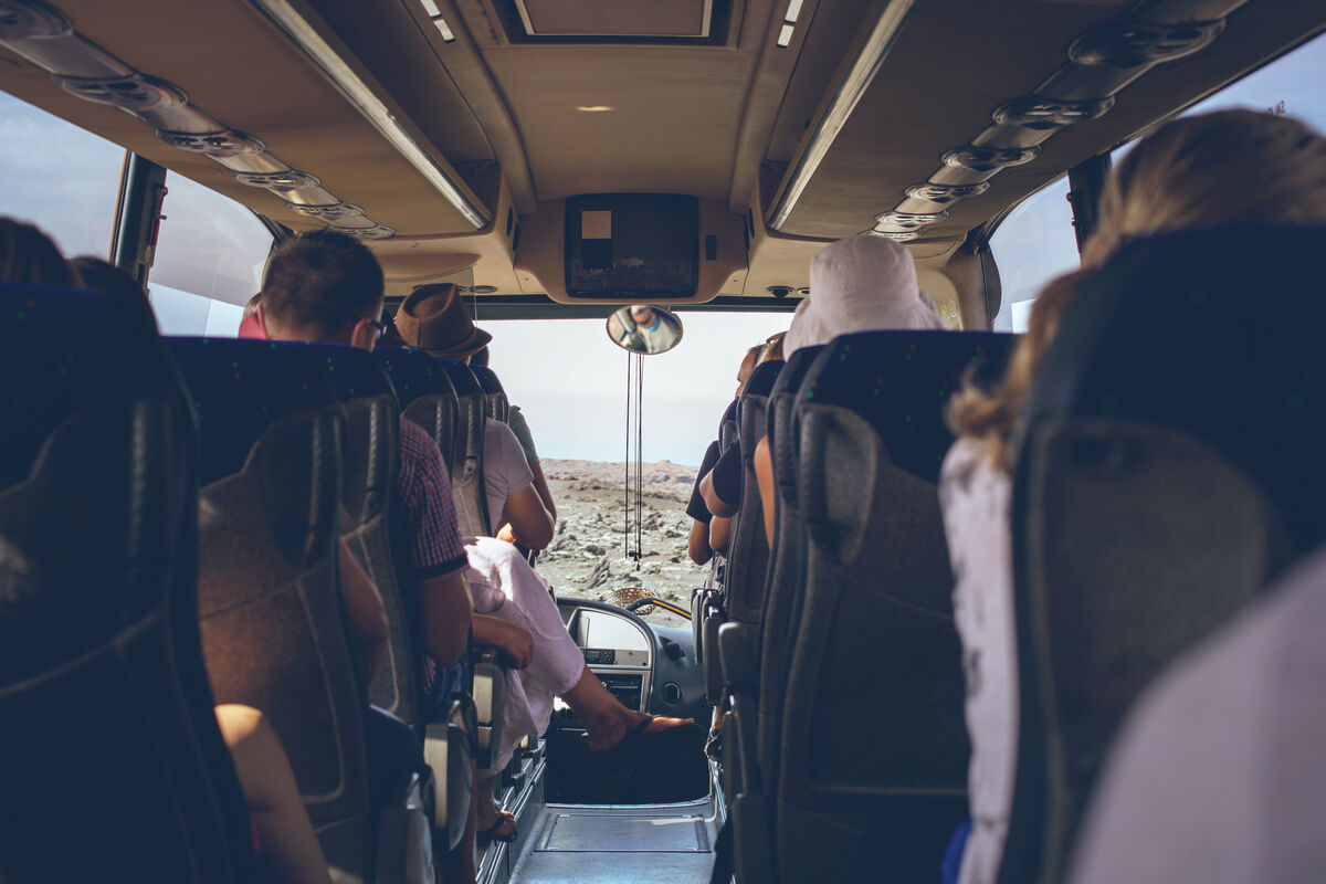 Passengers seated inside a large group vehicle looking out at the view
