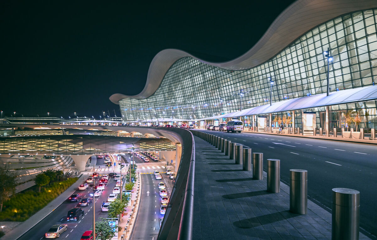Night-time airport terminal with vehicles in the pickup and drop-off lanes