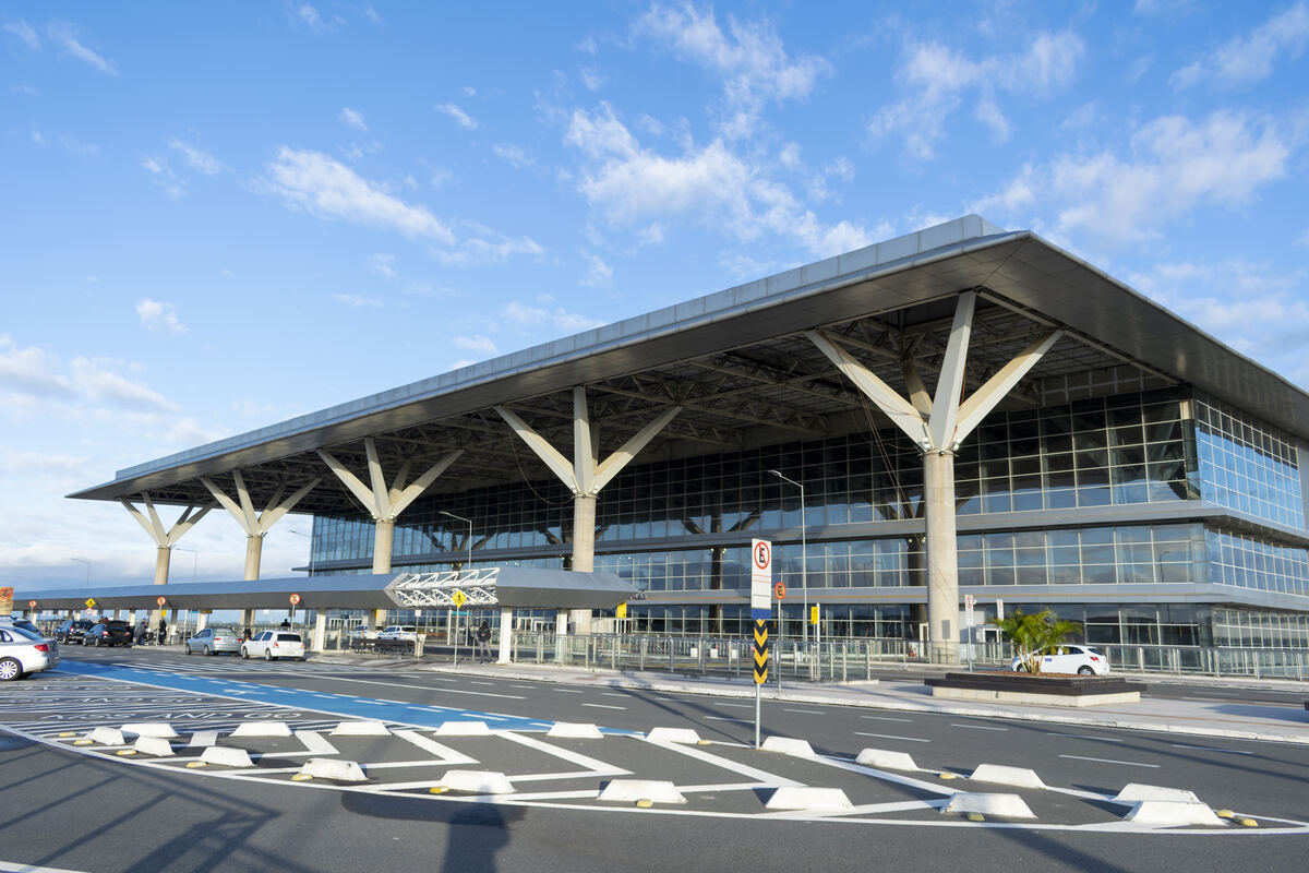 Airport terminal facade with passenger pickup and kiss-and-go lanes