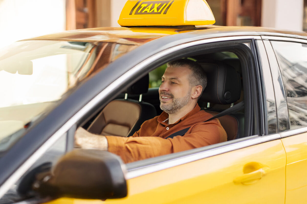 A taxi driver at the wheel of a cab