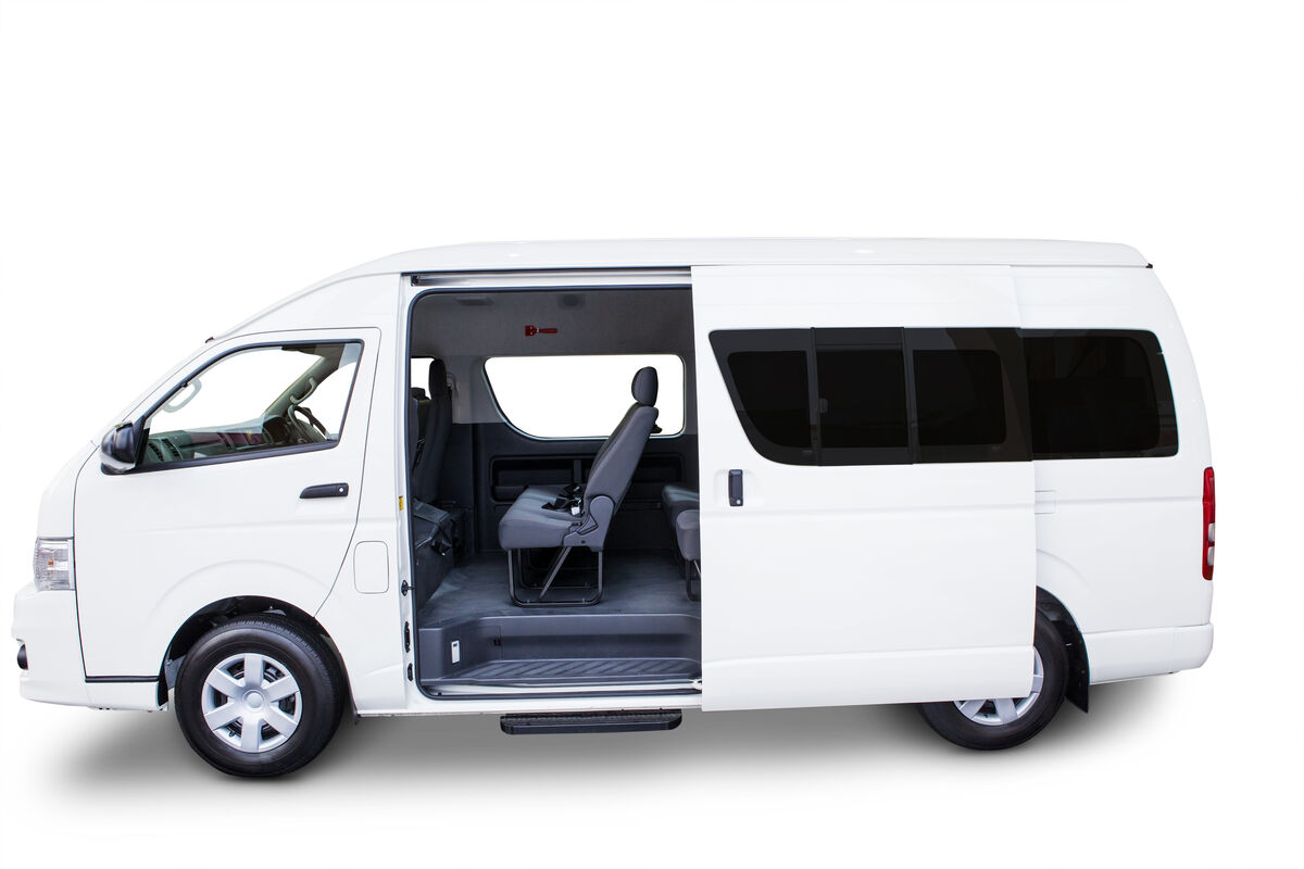 A twelve-seat passenger van with its side door open